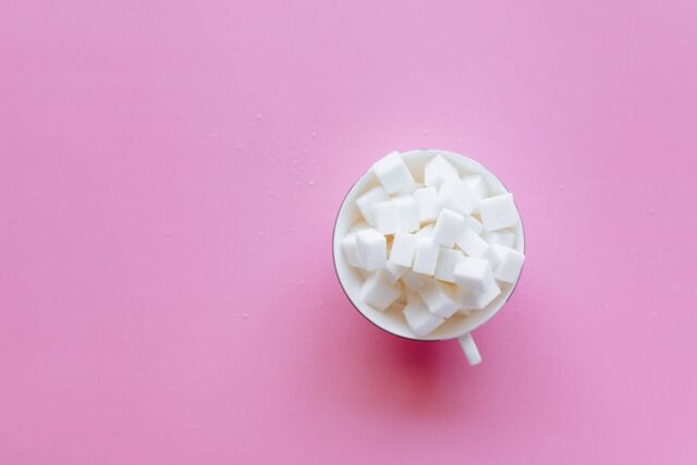 how-sugar-sabotages-your-memory-image human brain surrounded by refined sugar cubes neuroinflammation cognitive health memory impairment