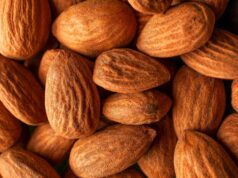 The Daily Handful: Scientists Reveal the Triple Impact of Almonds on Health handful of raw almonds on a wooden table